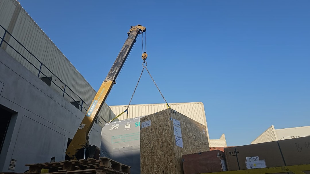 CT gantry crate being handled by crane during project logistics